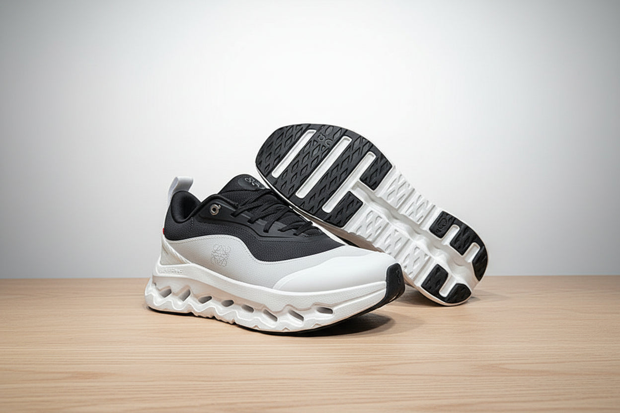 Black and white athletic shoes on a gray surface with a black background