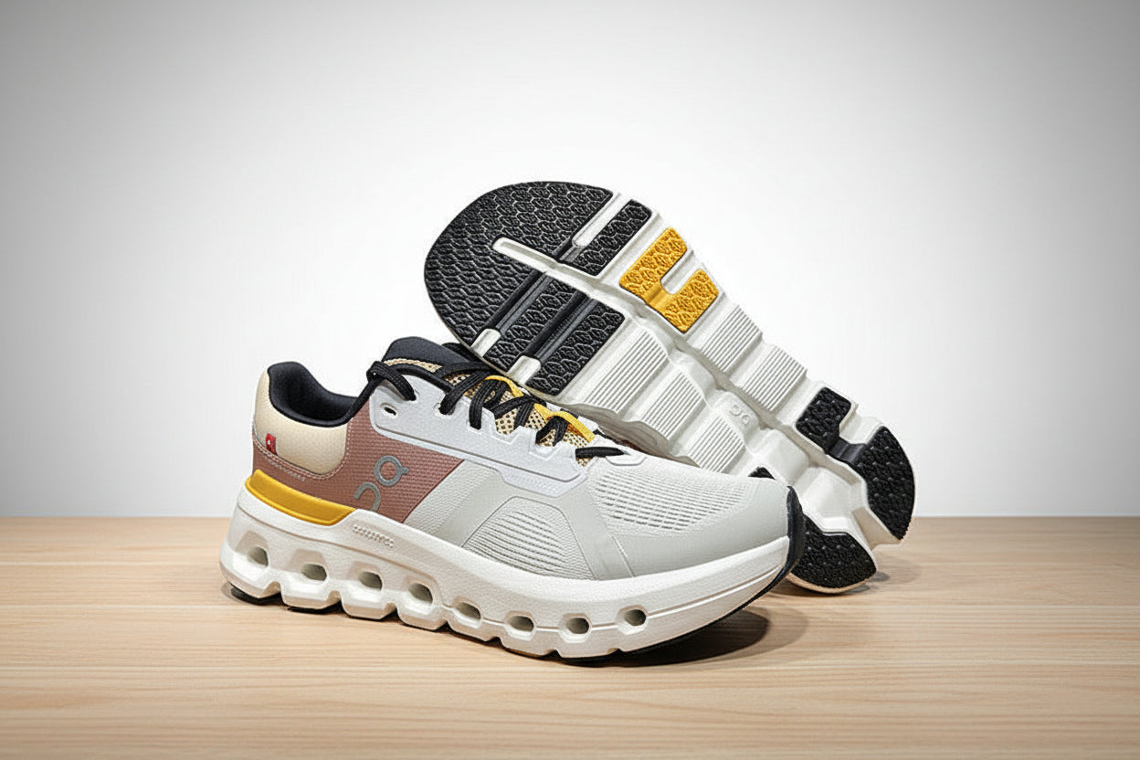 White sneakers with black, yellow, and gray accents on a light gray surface.