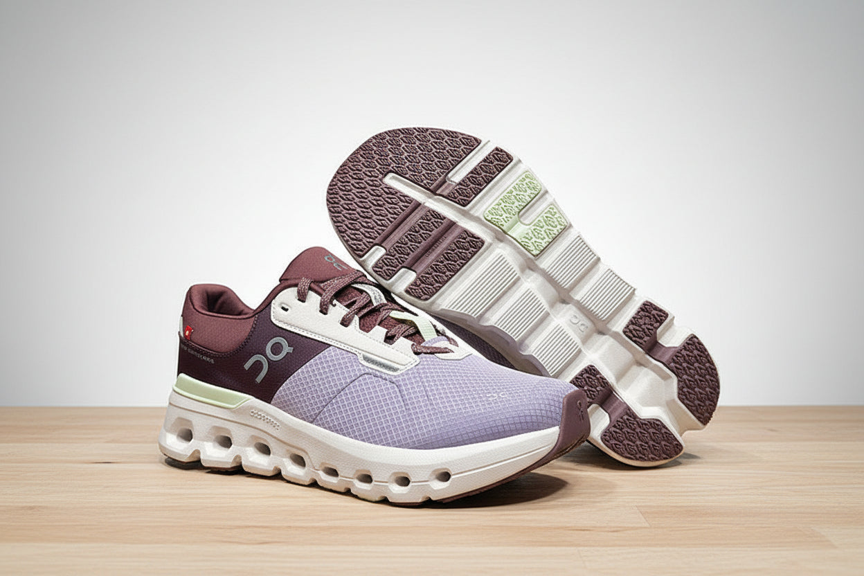 Pair of purple and white running shoes on a light gray surface with a black background