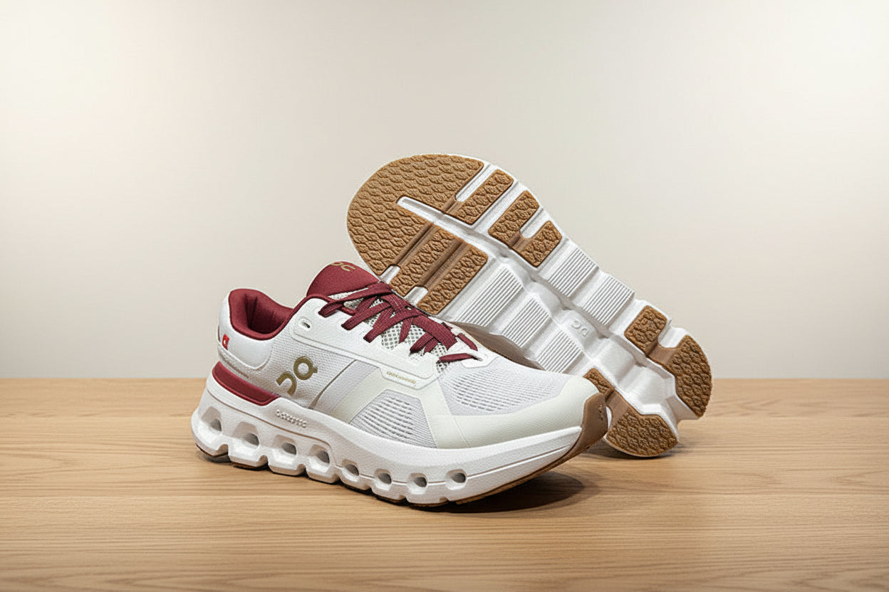 White and maroon sneakers with brown soles on a gray surface
