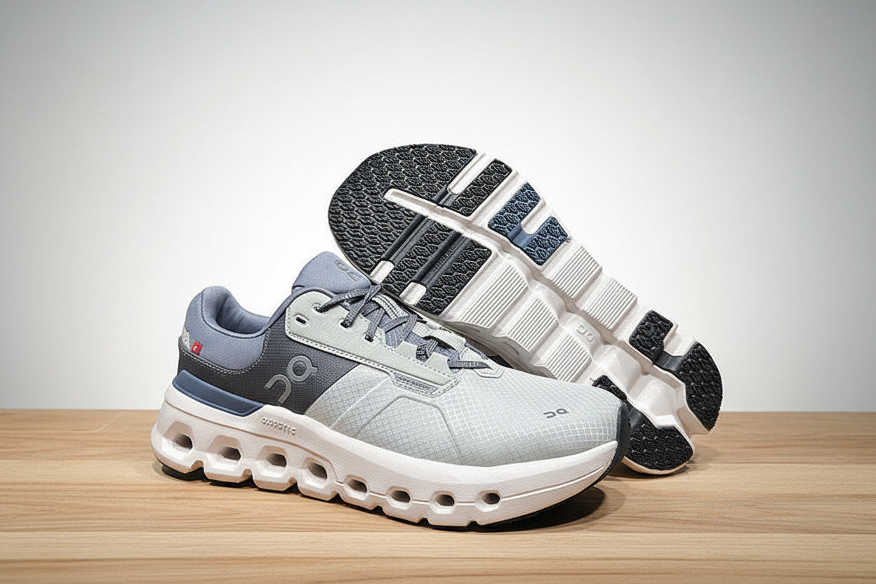 Pair of gray and blue athletic shoes on a light gray surface with a black background