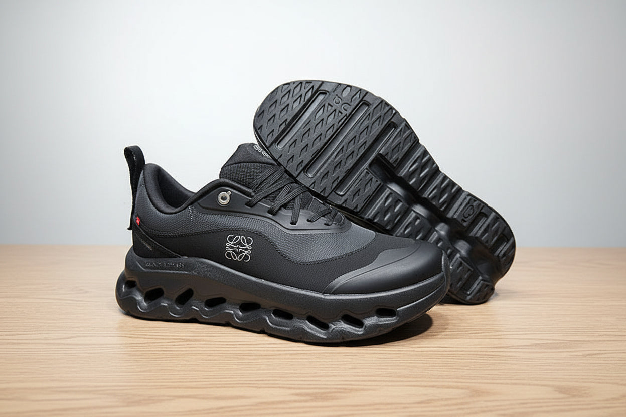 Gray athletic shoes with a brand logo on a white surface and black background