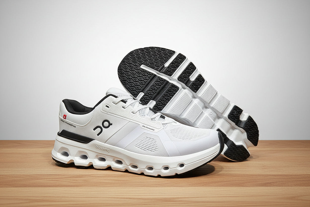 White athletic shoes with black accents on a light gray surface