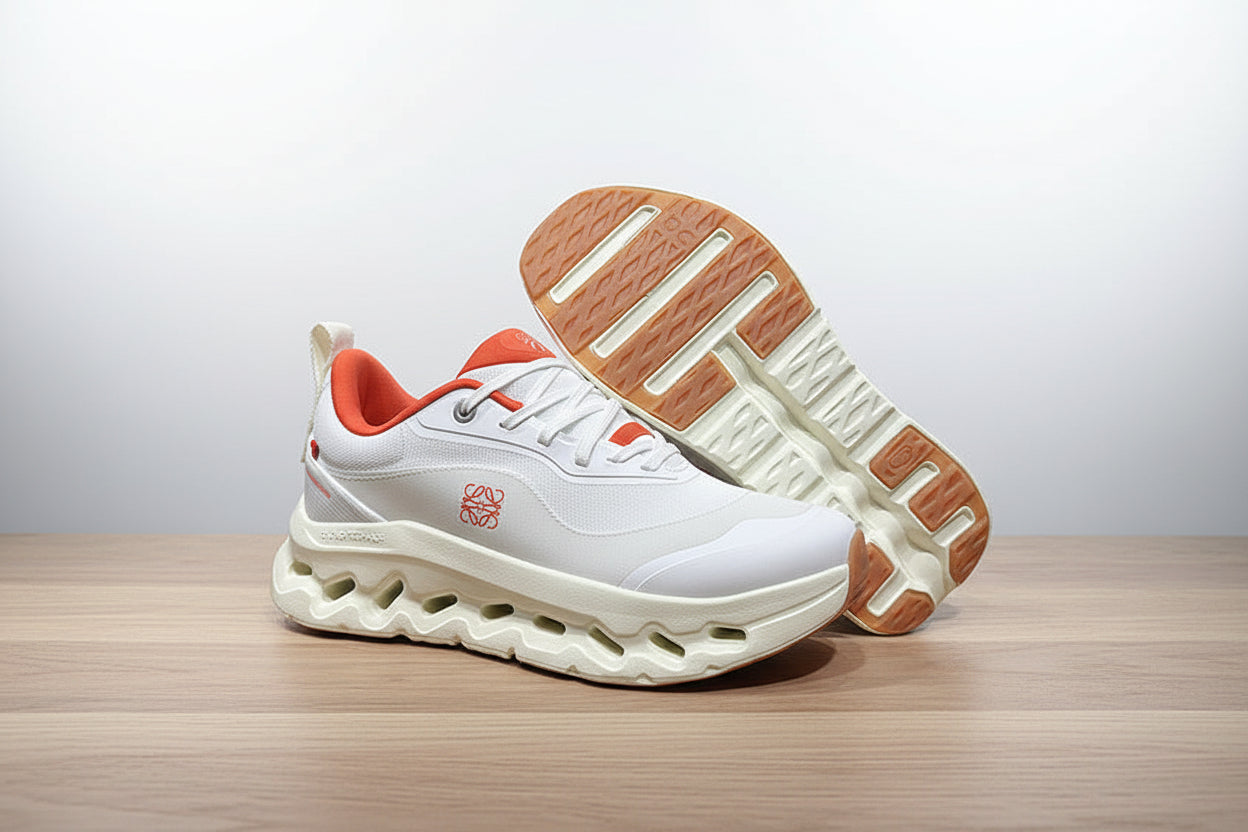 White sneakers with orange accents on a gray surface