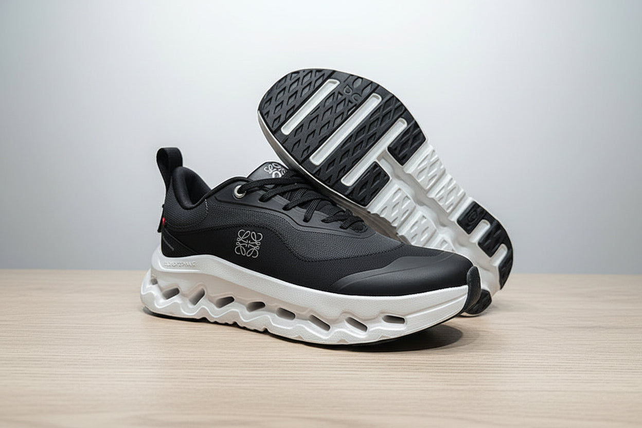 Black and white athletic shoe on a gray surface with a black background