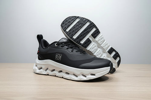 Black and white athletic shoe on a gray surface with a black background