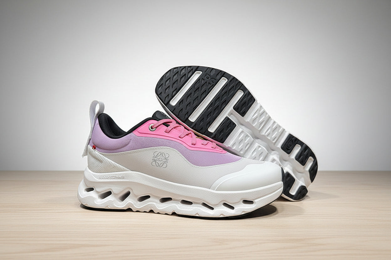 White and pink sneakers with a black sole on a gray surface