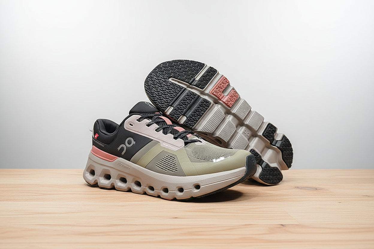 Gray and pink athletic shoes on a white surface with a black background